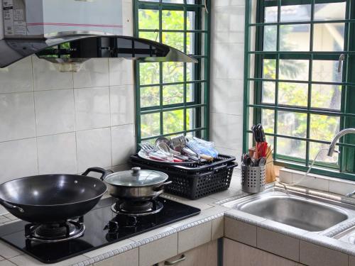 a kitchen with a stove with a pan on it at Together Hideaway Cheras 22pax 5R4B KTV, BBQ, ARCADE GAMES CHINESE, MALAY ONLY in Cheras