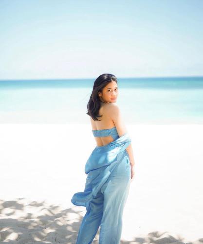 a woman in a blue dress walking on the beach at Nusa Dua Cliff Ocean View with Private Beach in Nusa Dua