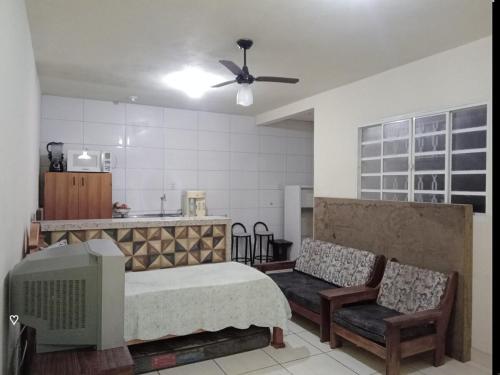 a living room with a bed and a kitchen at Edicula Paz e Amor in Piracicaba