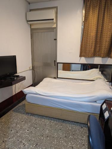 a large bed in a room with a television at Golden Dragon Hotel in Houlong