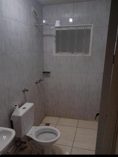 a small bathroom with a toilet and a sink at Edicula Paz e Amor in Piracicaba