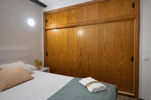 a bedroom with a wooden cabinet and a bed at Mini Peixcateria B in Sagunto