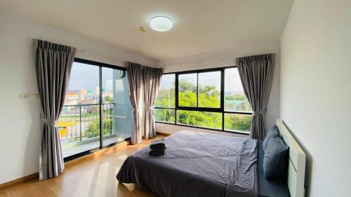 a bedroom with a bed and large windows at Vista Residence Old Town in Phuket