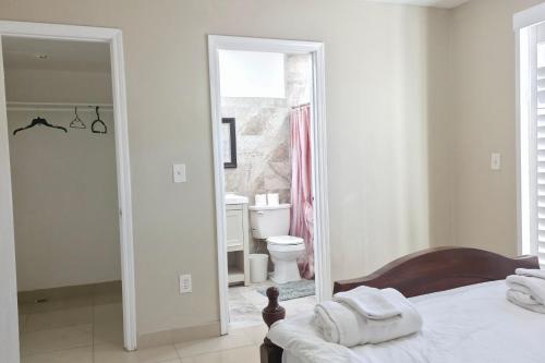 a white bedroom with a bed and a bathroom at Los Angeles Retreat Close to Hotspots in Los Angeles