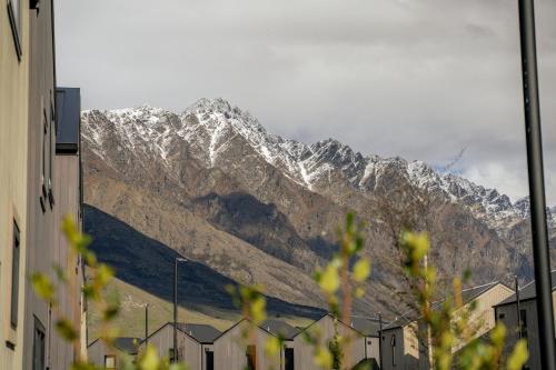 a snow covered mountain in the middle of a city at Ski Villa with Carpark 40, Stylish Alpine Base in Queenstown