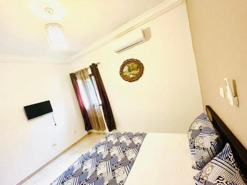 a bedroom with a bed and a clock on the wall at Résidence Ephrata in Cocody