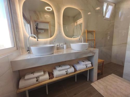 a bathroom with two sinks and a mirror at Modular Bungalows With Heated Pool Artemis Greece in Artemida