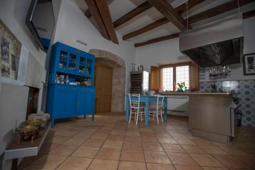a large kitchen with blue cabinets and a table at Palazzo Tronconi agriturismo in Arce