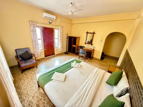 a bedroom with a large bed and a chair at The Mountain House in Pokhara