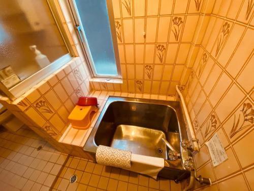 a small kitchen with a sink and a window at HOTEL Saboten Apartment in Miyoshi