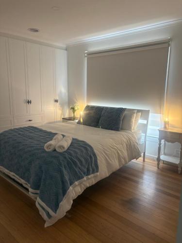 a bedroom with a large bed with two towels on it at Willow Place in Mornington
