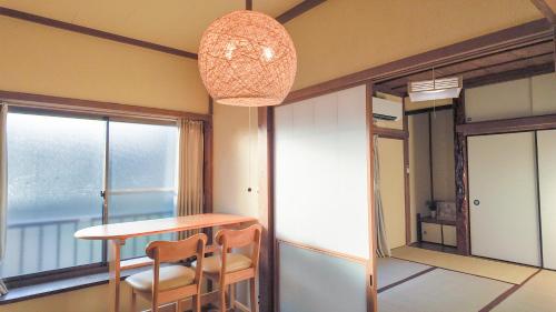 a dining room with a table and chairs and a chandelier at FUNAKATA MINA House in Tateyama