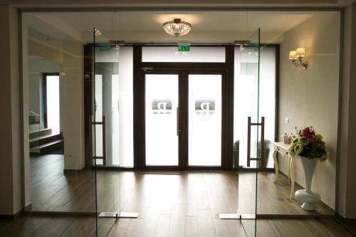 a lobby with a glass door with a vase of flowers at Pensiunea Rustik Lancram in Sebeş