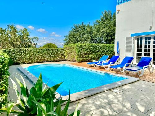 a swimming pool with blue lounge chairs next to a house at Casa da Eira - Private Villa - pool - Free wi-fi - Air Con in Silves