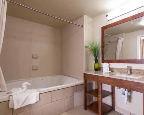 a bathroom with a tub and a sink at Comfort Suites Tulsa Central in Tulsa