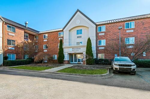 a car parked in front of a brick building at MainStay Suites Greensboro in Greensboro