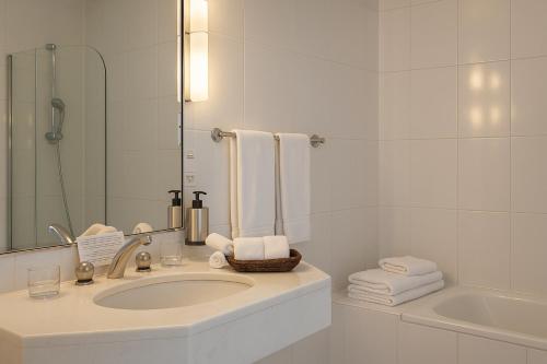 a bathroom with a sink and a mirror and a tub at Hotel Du Parc - Mulhouse Centre in Mulhouse