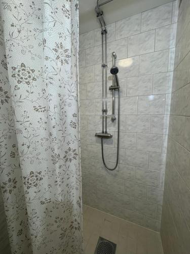 a shower with a shower curtain in a bathroom at Laplanders room 14 in Kiruna