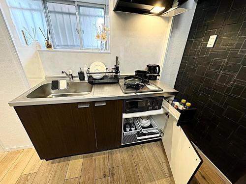 a small kitchen with a sink and a stove at K-ART Stay Shinsakae2 in Nagoya