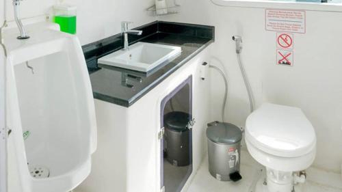 a small bathroom with a toilet and a sink at GiliTicket fast ferries in Padangbai