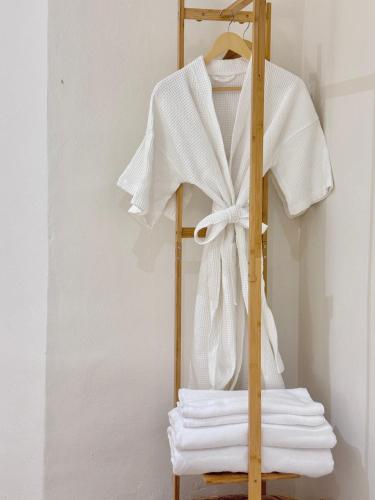 a towel rack with a white shirt and towels at Quies Hotel in Krabi