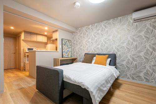 a bedroom with a bed and a wall at C L Susukino in Sapporo