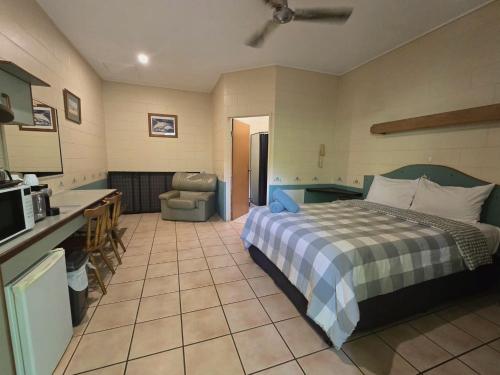 a bedroom with a bed and a kitchen with a sink at Curtain Fig Motel in Yungaburra
