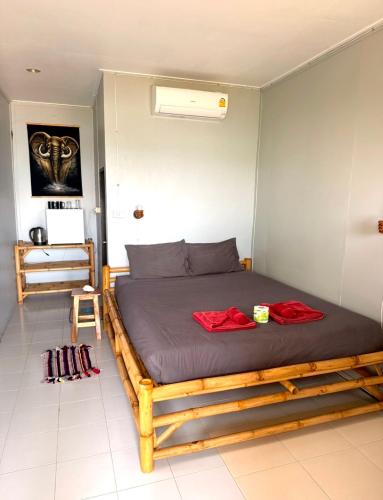 a bedroom with a wooden bed in a room at Last Hammock Beach Resort in Baan Khai