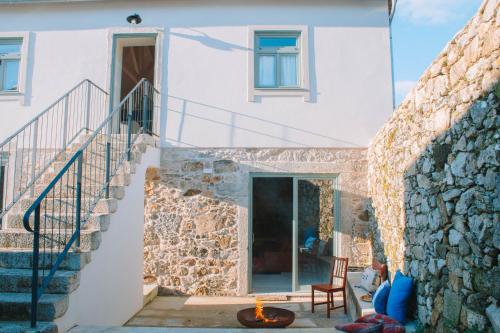 a house with a stone wall and a staircase at Just Like Home - Casa da Tuca in Moledo