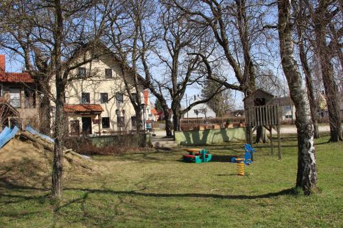 a playground in front of a house with trees at Gasthof Zur Post in Schwabhausen bei Dachau