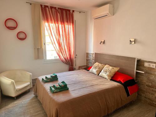 a bedroom with a bed and a chair and a window at Apartaments IRI in Pineda de Mar