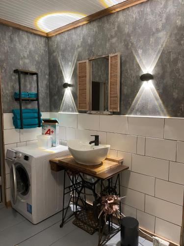 a bathroom with a sink and a washing machine at Villa Björksele in Björksele