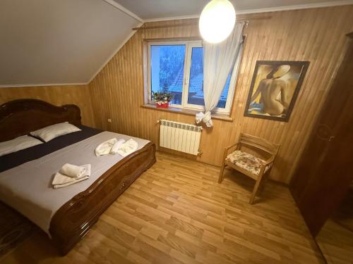 a bedroom with a bed and a chair and a window at Hotel palas tatariv in Tatariv