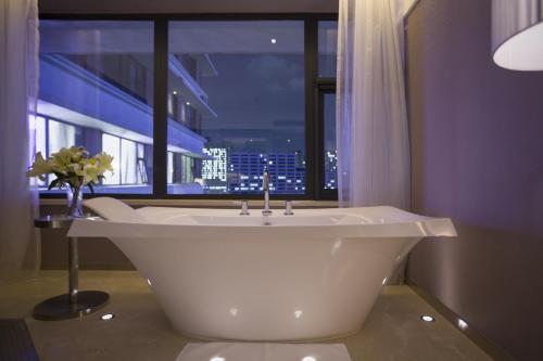 een badkamer met een wit bad en een raam bij Crystal Orange Hotel Guangzhou Taojin Branch in Guangzhou