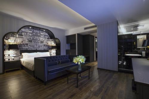 een slaapkamer met een bed, een bank en een tafel bij Crystal Orange Hotel Guangzhou Taojin Branch in Guangzhou