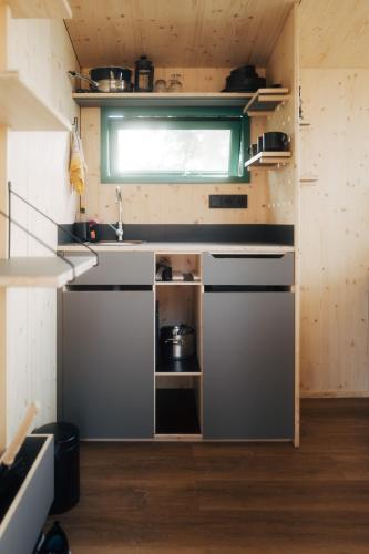 a small kitchen with a sink and a stove at Tiny Houses Klein Ahoi Camp Canow in Wustrow