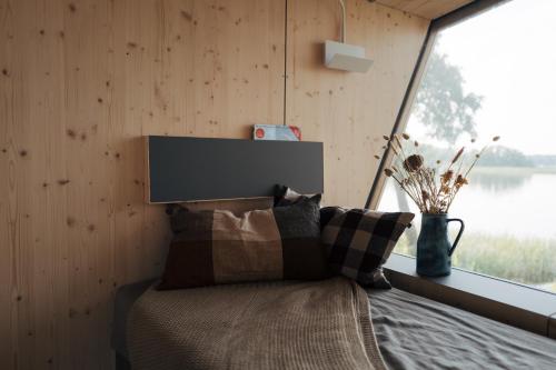 a bedroom with a bed with a large window at Tiny Houses Klein Ahoi Camp Canow in Wustrow