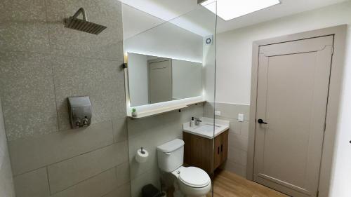 a bathroom with a toilet and a sink and a mirror at La Carolina Suite Moderna - Excelente Ubicación in Quito