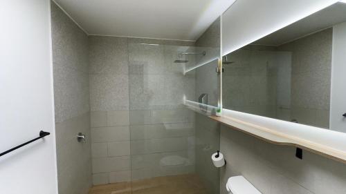 a bathroom with a shower and a toilet and a mirror at La Carolina Suite Moderna - Excelente Ubicación in Quito