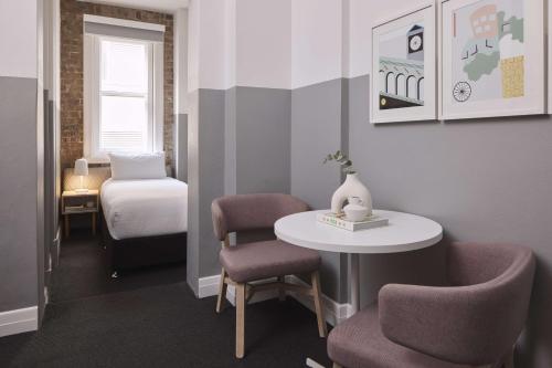 a small room with a table and chairs and a bed at The Ultimo in Sydney