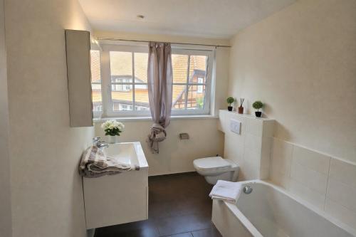 a bathroom with a tub and a toilet and a sink at Pferdeparadies Untergrünhagen in Bad Fallingbostel