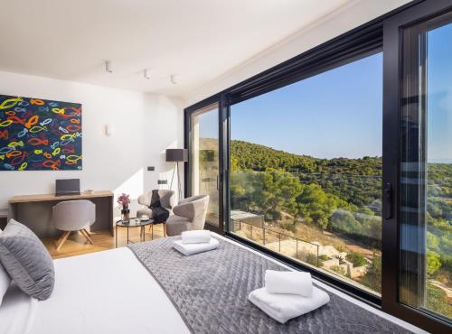 ein Schlafzimmer mit einem Bett und einem großen Fenster in der Unterkunft Breathtaking Villa Vis in Vis