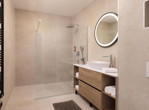 ein Badezimmer mit Dusche, Waschbecken und Spiegel in der Unterkunft Breathtaking Villa Vis in Vis