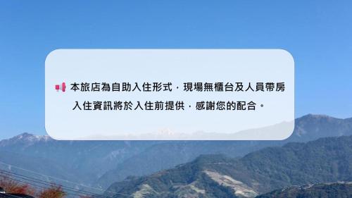 a sign with writing on it with mountains in the background at 清境77窩House-包棟包層民宿 in Ren'ai