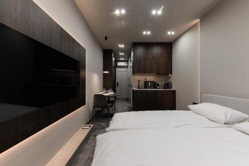 a bedroom with a large white bed and a desk at EVURI Apartments BUDAPEST 2 in Uzhhorod