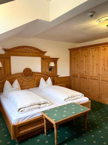 a bedroom with two beds and a table at Gasthof & Hotel Jägerwirt in Aufhofen