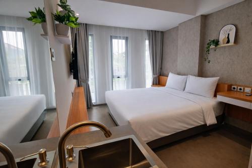 a hotel room with a bed and a sink at The Orchid by FLAT06 in Jakarta