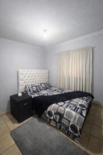 a bedroom with a bed and a window at PrimeStay One 2 Bedroom Apartment in Johannesburg