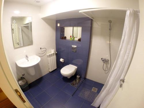 a blue and white bathroom with a toilet and a sink at Beit Wadih in Ghazīr