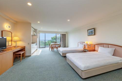 a hotel room with two beds and a television at YU-FURI Izukogen in Ito